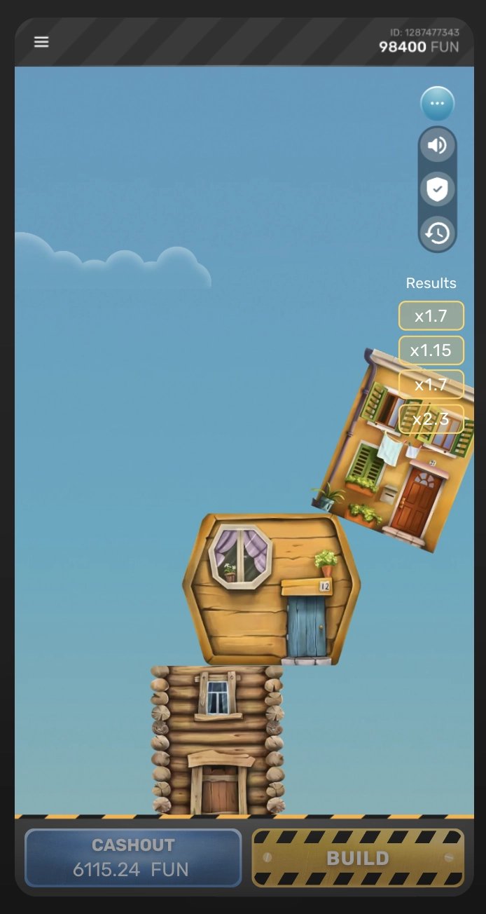 Interface du jeu de la tour casino en mode FUN qui, montre un &eacute;tage de maison en train de tomber de travers au-dessus d&rsquo;une base en bois, les multiplicateurs r&eacute;cents sont affich&eacute;s &agrave; droite (x1.7, x1.15, x2.3), avec un bouton CASHOUT qui affiche 6115.24 FUN en bas &agrave; gauche et un bouton BUILD jaune et noir visible &agrave; droite, avec un ciel bleu en arri&egrave;re-plan avec des nuages.